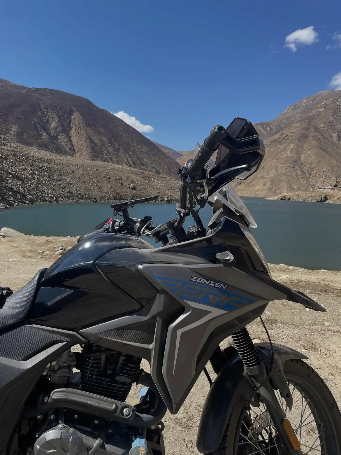 Adventure motorcycle beside a high mountain lake