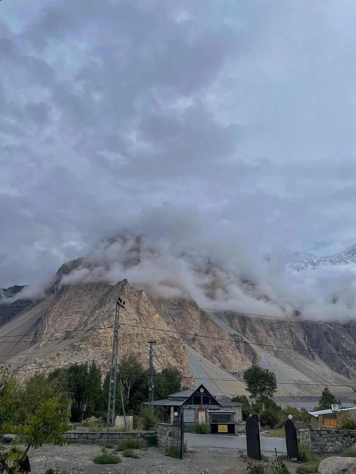 Cloud-covered mountains above a settlement in northern Pakistan